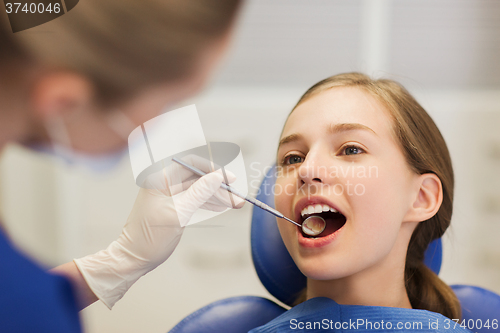 Image of female dentist checking patient girl teeth