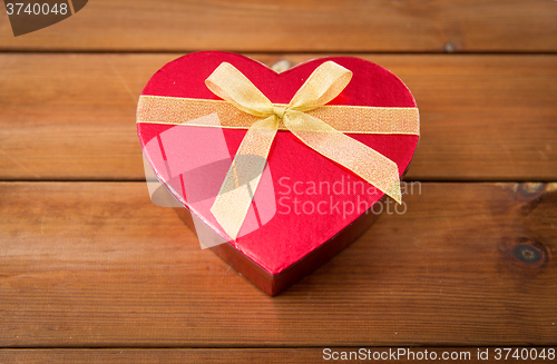 Image of close up of heart shaped gift box on wood