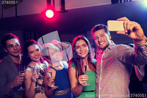 Image of friends with glasses and smartphone in club