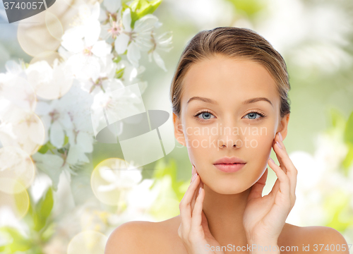 Image of young woman touching her face