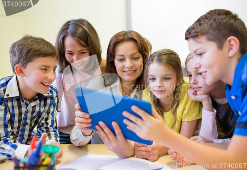 Image of group of kids with teacher and tablet pc at school