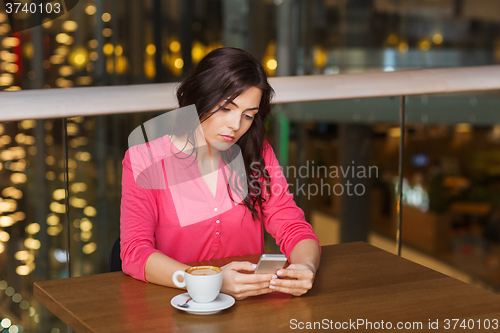 Image of woman with smartphone and coffee at restaurant