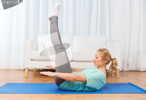 Image of woman exercising on mat at home