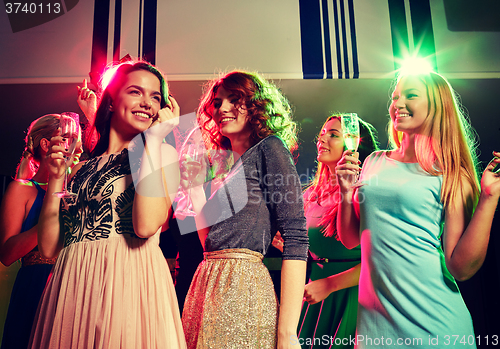 Image of smiling friends with glasses of champagne in club