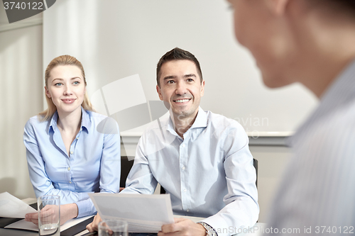 Image of group of smiling businesspeople meeting in office