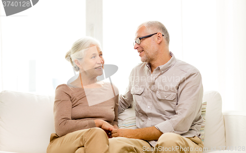 Image of happy senior couple sitting on sofa at home