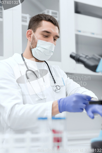 Image of young male scientist wearing gloves in lab