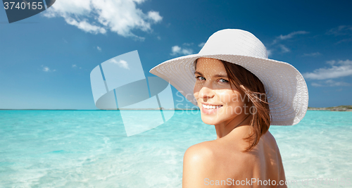 Image of happy young woman in sunhat over summer beach