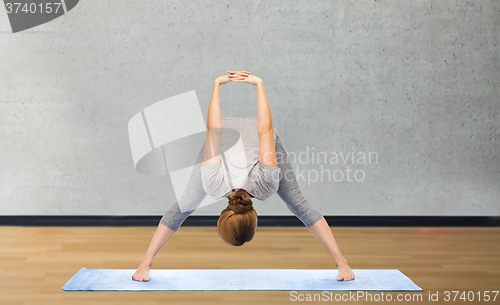 Image of woman making yoga in wide-legged forward bend pose
