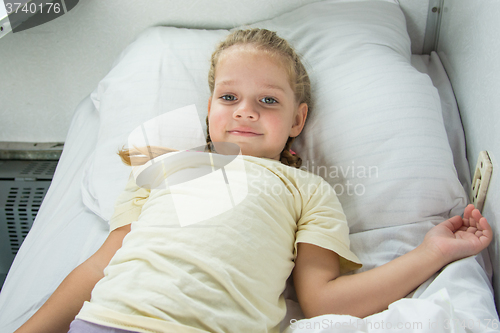 Image of Four-year girl lies on a bed in a train