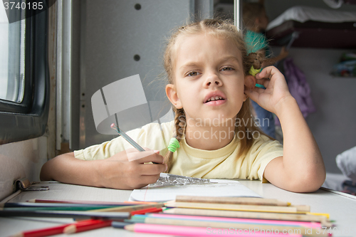 Image of A six-year girl in the picture looked drawing pencils in a second-class train carriag