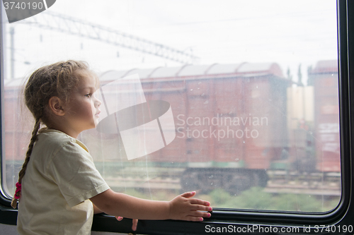 Image of Girl thoughtfully looking into the distance from a train window
