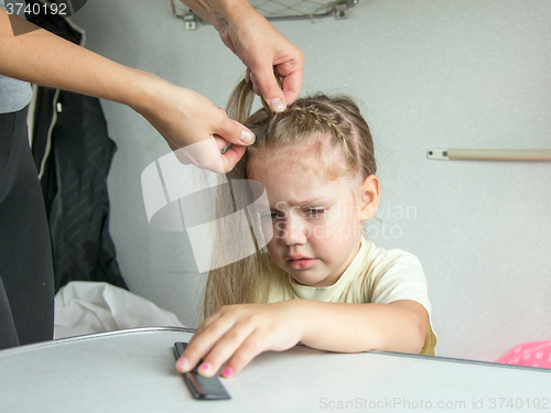 Image of Four-year girl cries in pain when my mother combing her hair