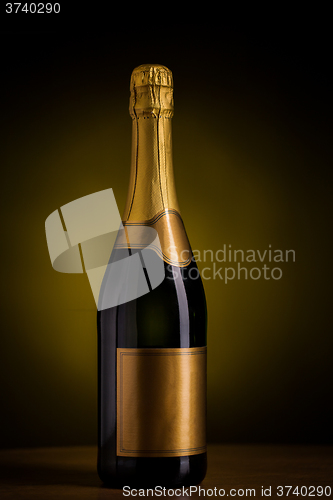 Image of bottle of champagne with blank golden label