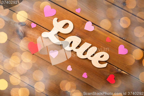 Image of close up of word love with red paper hearts