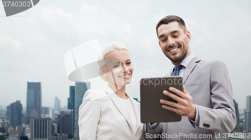 Image of smiling businessmen with tablet pc in city