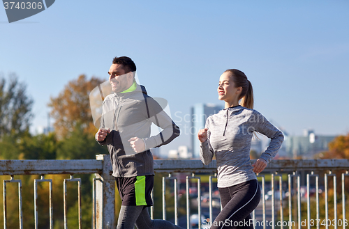 Image of happy couple running outdoors