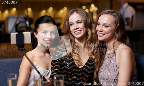 Image of women with smartphone taking selfie at night club