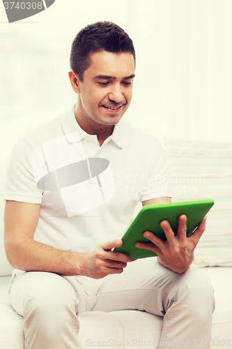 Image of smiling man working with tablet pc at home