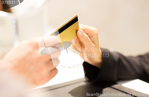 Image of close up of hand giving credit card to seller