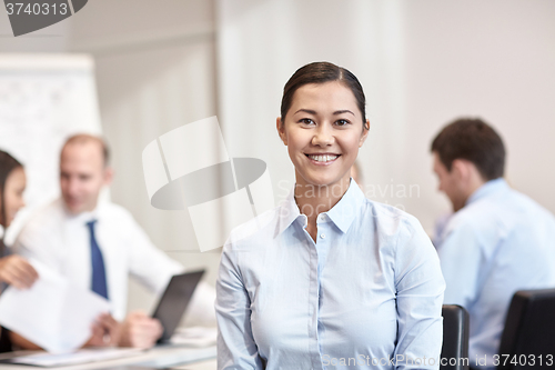 Image of group of smiling businesspeople meeting in office