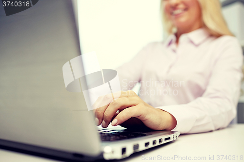 Image of smiling businesswoman or student typing on laptop