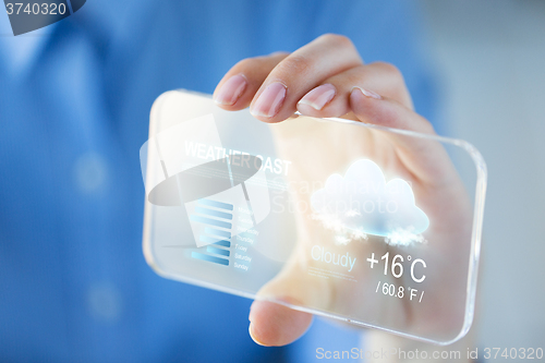 Image of close up of woman with weather cast on smartphone