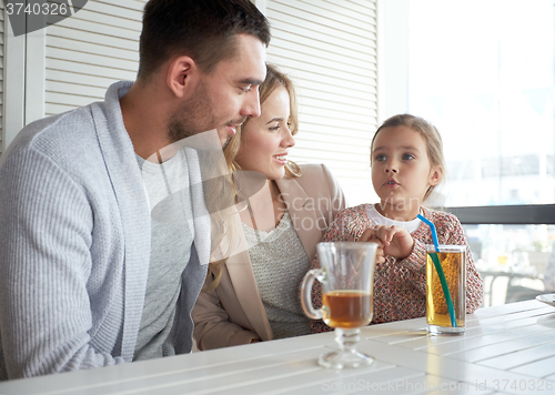 Image of happy family having dinner at restaurant or cafe