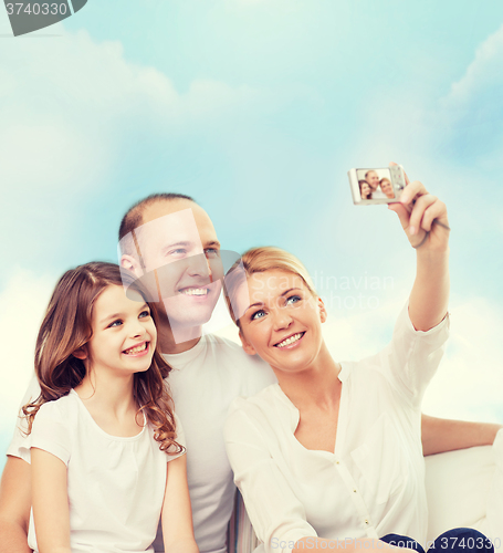 Image of happy family with camera at home