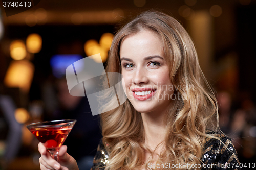 Image of glamorous woman with cocktail at night club or bar