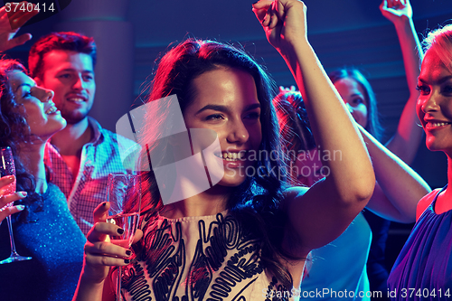 Image of smiling friends with glasses of champagne in club