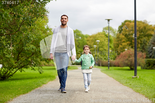 Image of happy family walking in summer park