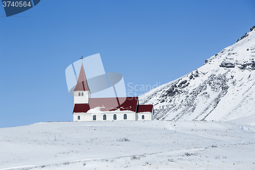 Image of Church of Vik in wintertime with snowy mountains, Iceland