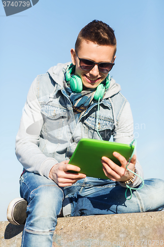 Image of happy young man with tablet pc and headphones