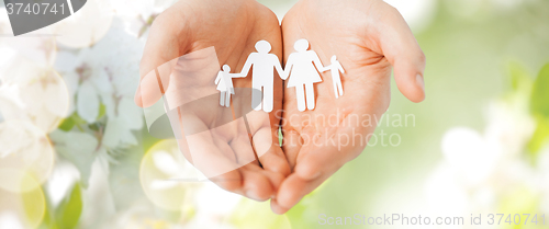 Image of man hands holding paper cutout of family