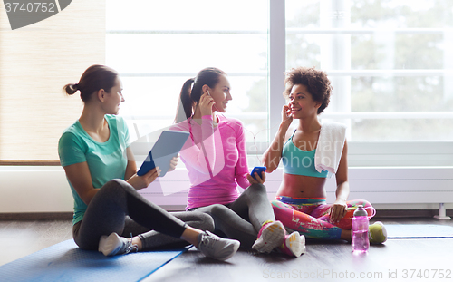 Image of happy women listening to music in gym