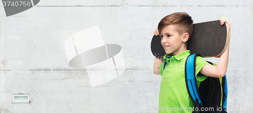 Image of happy student boy with backpack and skateboard