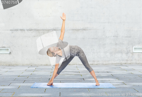 Image of woman making yoga triangle pose on mat