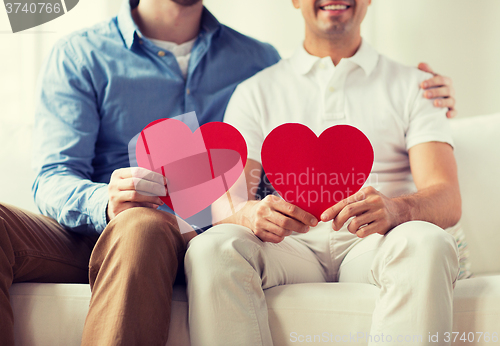 Image of close up of happy gay male couple with red hearts