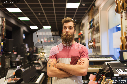 Image of assistant or customer with beard at music store