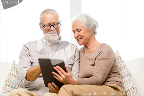 Image of happy senior couple with tablet pc at home