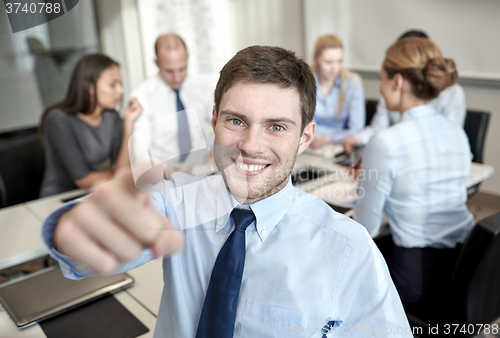 Image of group of smiling businesspeople meeting in office