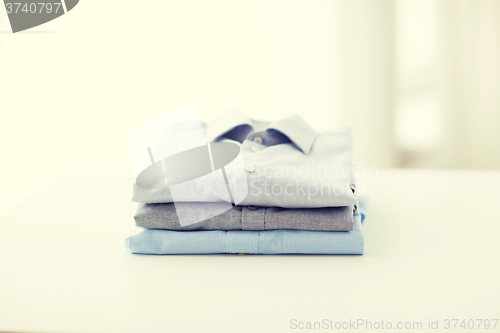Image of close up of ironed and folded shirts on table