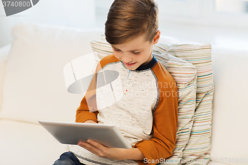 Image of smiling boy with tablet computer at home