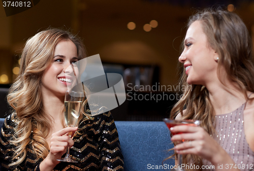 Image of happy women with drinks at night club