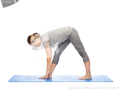 Image of woman making yoga intense stretch pose on mat