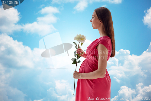 Image of happy pregnant woman with rose flower