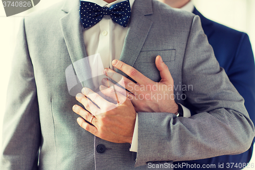 Image of close up of male gay couple with wedding rings on