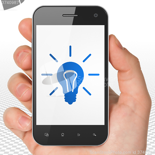 Image of Business concept: Hand Holding Smartphone with Light Bulb on display