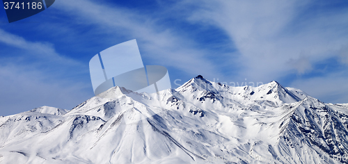 Image of Panoramic view on winter snowy mountains in windy day